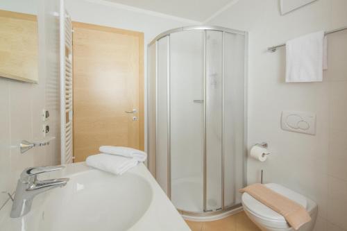 La salle de bains est pourvue d'une douche, d'un lavabo et de toilettes. dans l'établissement Ciasa Vilin, à Corvara in Badia