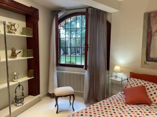 ein Schlafzimmer mit einem Bett, einem Fenster und einem Stuhl in der Unterkunft il loggiato 1 in Castelfranco Veneto