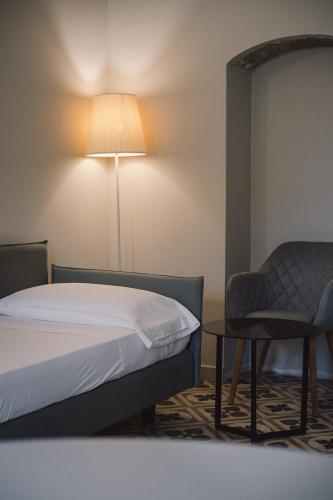 a bedroom with a bed and a chair and a lamp at Masseria Agriturismo Torre Di Albidona in Trebisacce