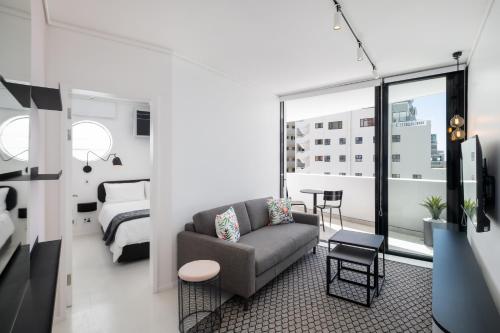 a living room with a couch and a bedroom at The Flamingo Private Apartments by Perch Stays in Cape Town