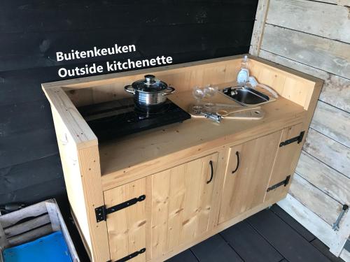 a wooden kitchen with a sink and a stove at Natuurhuisje Gouderak in Gouderak