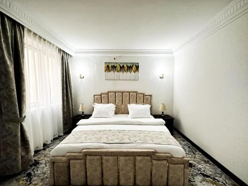 a bedroom with a large bed with a large headboard at Al Massa Hotel in Al Ain