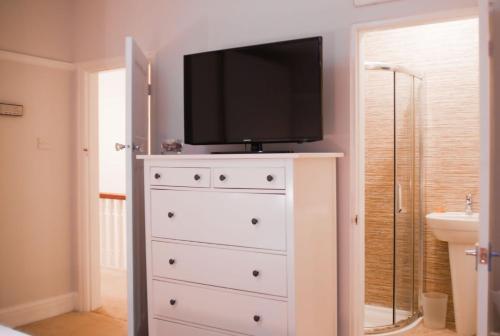 a dresser with a television on top of it at "Rosecroft" - Perfect Retreat for Business & Leisure - Close to Celtic Manor and ICC in Newport