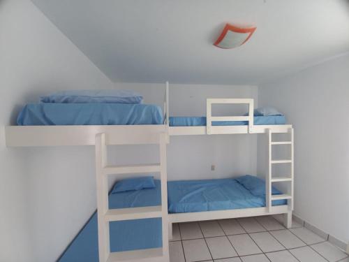 Camera con 3 letti a castello e lenzuola blu di Departamento super cómodo Playa Naplo a Naplo