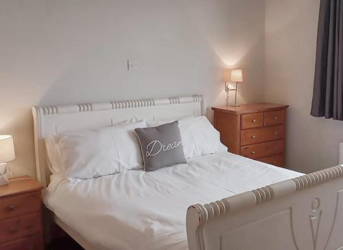 a bedroom with a bed with white sheets and pillows at Sarlyn Holiday Home Achill in River
