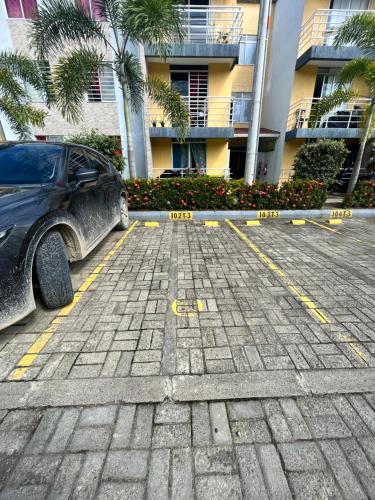 a car parked in a parking lot in front of a building at Apartamentos Sierra Verde Living in Apartadó