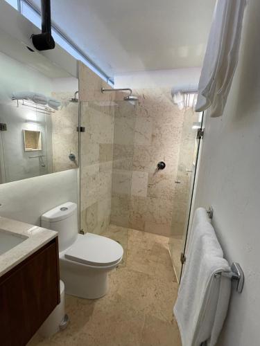 a bathroom with a toilet and a glass shower at Las Lupitas Hotel Boutique in Campeche