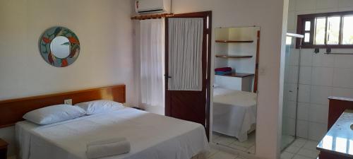 a bedroom with a bed and a bathroom with a shower at Meu Porto Seguro - Taperapuã in Porto Seguro