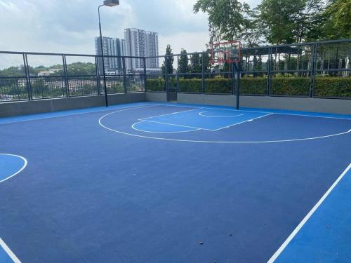 a tennis court with a blue tennis court at Equine Residence Getaway in Seri Kembangan