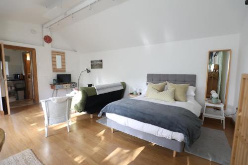 a bedroom with a large bed and a chair at Garden Studio in Biggar in Biggar