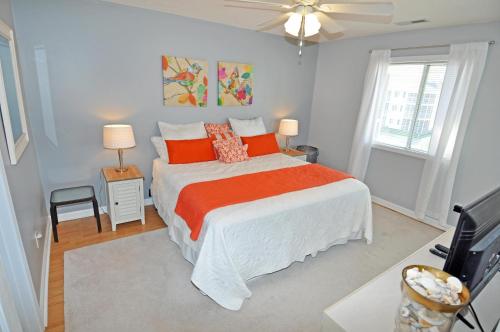 a bedroom with a bed with an orange blanket at Waterway Landing Gated Community 2BR Condo in Myrtle Beach