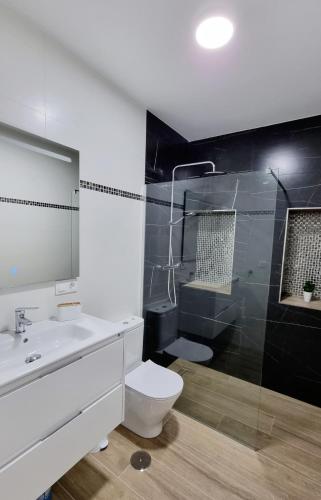 a bathroom with a toilet and a sink and a shower at Vivienda Turística Playa El Portil in El Portil