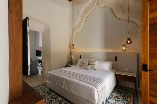 a bedroom with a large white bed in a room at Las Lupitas Hotel Boutique in Campeche