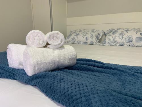a bed with towels and a blue blanket at Villa Das Conchas in Palhoça