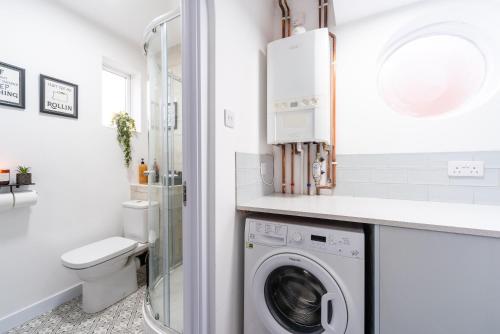 a bathroom with a washing machine and a toilet at Nhyira Private Parking CHic Three Bedrooms Garage 2 Shower rooms Classy Home in Hull