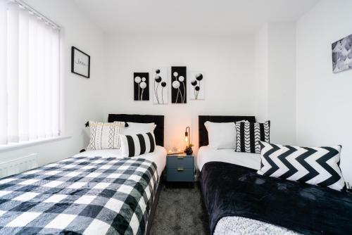 two beds sitting next to each other in a bedroom at Nhyira Private Parking CHic Three Bedrooms Garage 2 Shower rooms Classy Home in Hull