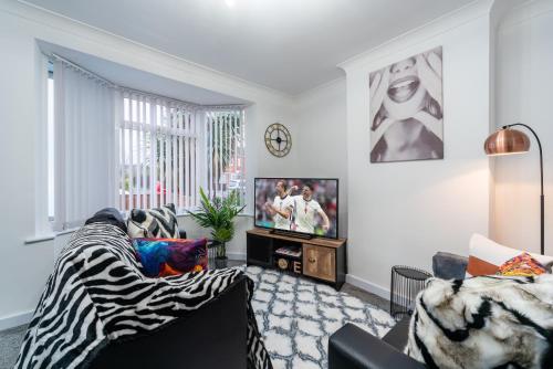 a living room with a zebra couch and a tv at Nhyira Private Parking CHic Three Bedrooms Garage 2 Shower rooms Classy Home in Hull