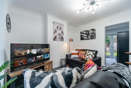 a living room with a couch and a flat screen tv at Nhyira Private Parking CHic Three Bedrooms Garage 2 Shower rooms Classy Home in Hull