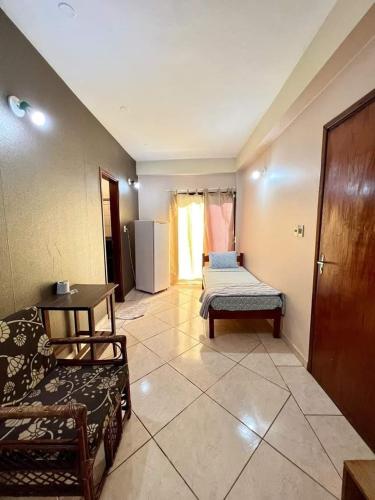 a room with a bed and a couch and a chair at Hotel Catedral in Ciudad del Este