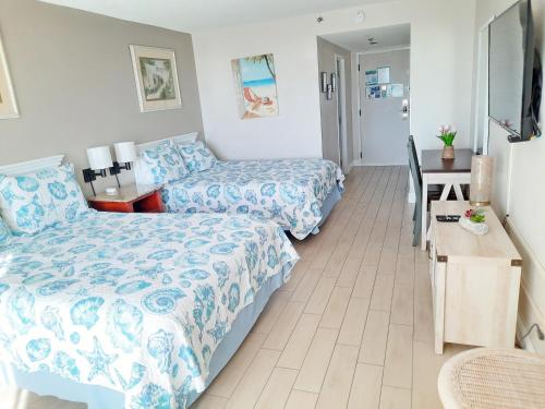a hotel room with two beds and a desk at Lovely Sandestin Resort Studio with Balcony and Sunset View in Destin