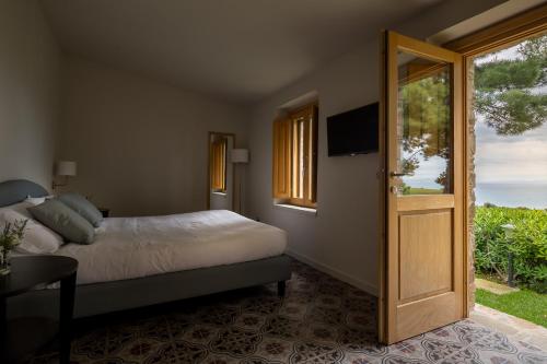 a bedroom with a bed and a sliding glass door at Masseria Agriturismo Torre Di Albidona in Trebisacce