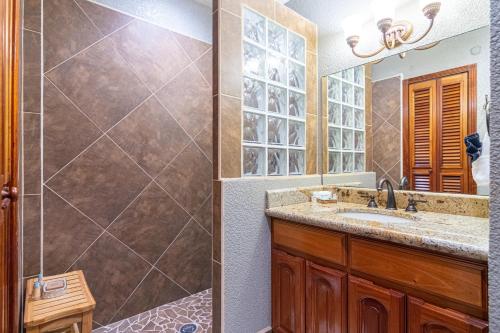 a bathroom with a shower and a sink and a mirror at Lighthouse Beach Villas in San Pedro