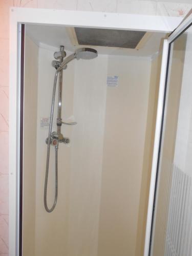 a shower with a shower head in a bathroom at 'The Cabin'. A cosy private & secure holiday home. in Padeswood