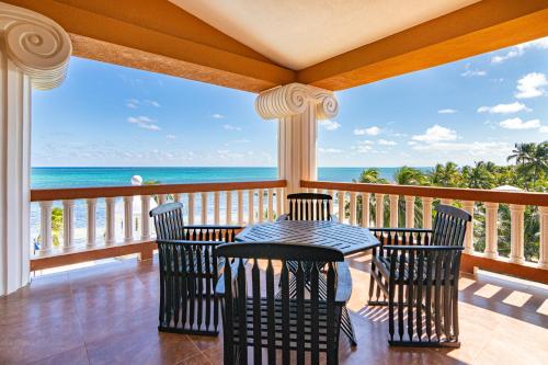 a porch with a table and chairs and the ocean at Lighthouse Beach Villas in San Pedro