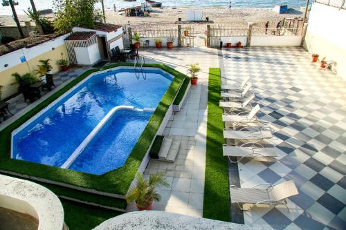 an overhead view of a swimming pool with chairs and the beach at Brisotel - Beira Mar in Luanda