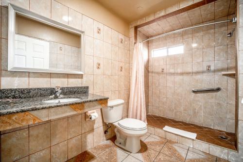 uma casa de banho com um WC, um lavatório e um chuveiro em Geneva Motel em Inglewood