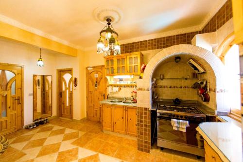 a large kitchen with a stove and an archway at Surfers-Lounge-Dahab Lagoon with Swimming-Pool - Breakfast - Garden - Beduintent - BBQ - Jacuzzi in Dahab