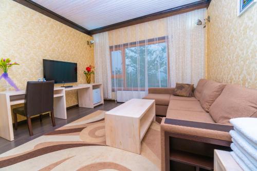 a living room with a couch and a desk at Ladera Resort Qusar in Qusar