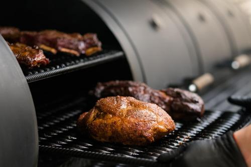 two pieces of meat cooking on a grill at Under Canvas North Yellowstone - Paradise Valley in Livingston