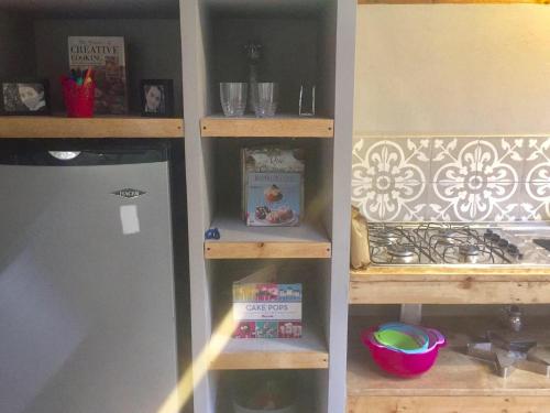 a kitchen pantry with a refrigerator and some shelves at Acogedora cabaña en el bosque, Via La Calera in La Calera