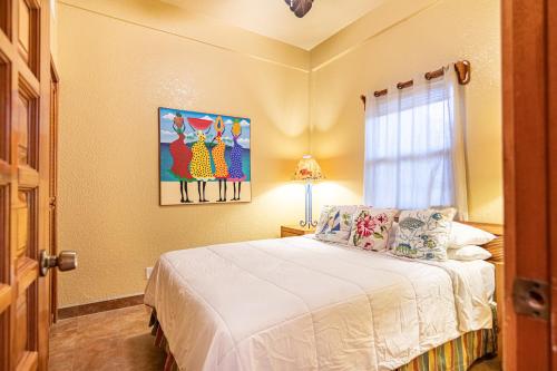 a bedroom with a white bed and a window at Lighthouse Beach Villas in San Pedro