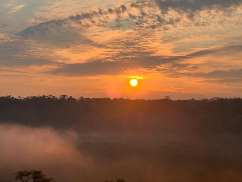 una puesta de sol con el sol saliendo sobre los árboles en Arahuana Jungle Resort & Spa, en Tena