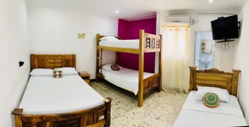 Pokój z 2 łóżkami piętrowymi i telewizorem w obiekcie Hostal Liwa Kashi w mieście Ríohacha