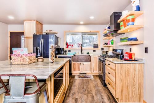 a kitchen with wooden cabinets and a black refrigerator at A Place To Gather in Tomahawk
