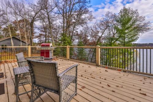 a wooden deck with two chairs and a grill on it at A Place To Gather in Tomahawk