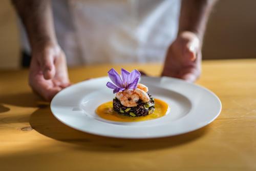 a plate of food with a purple flower on it at Masseria Agriturismo Torre Di Albidona in Trebisacce