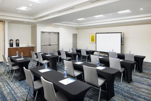a conference room with tables and chairs and a whiteboard at Holiday Inn Express Hotel & Suites Port St. Lucie West by IHG in Port Saint Lucie
