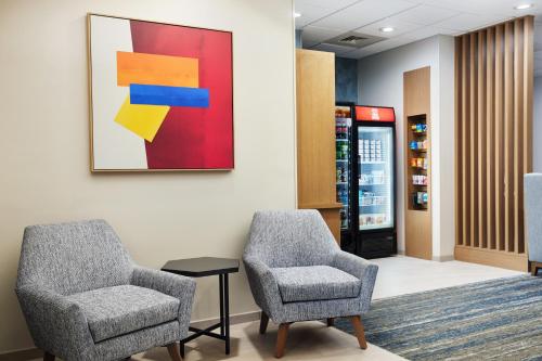 a waiting room with two chairs and a painting on the wall at Holiday Inn Express Hotel & Suites Port St. Lucie West by IHG in Port Saint Lucie