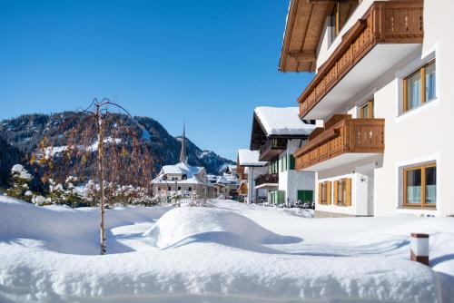 a snow covered street in front of a building at Hotel Vernel in Santa Cristina in Val Gardena