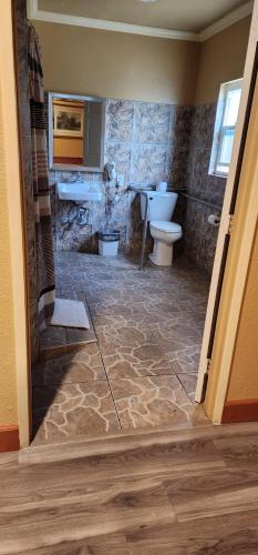 a bathroom with a toilet and a sink at Geneva Motel in Inglewood