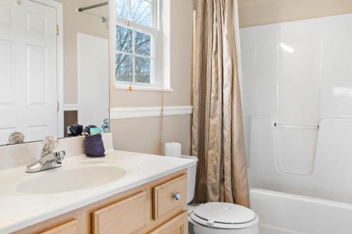 a bathroom with a sink and a toilet and a window at Rest Assured, WIFI, 685 FREE tickets each paid day!!! in Pigeon Forge