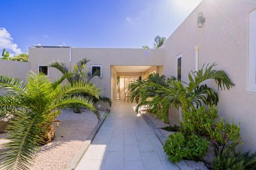 una casa con palmeras delante en Turibana 50 G, en Noord