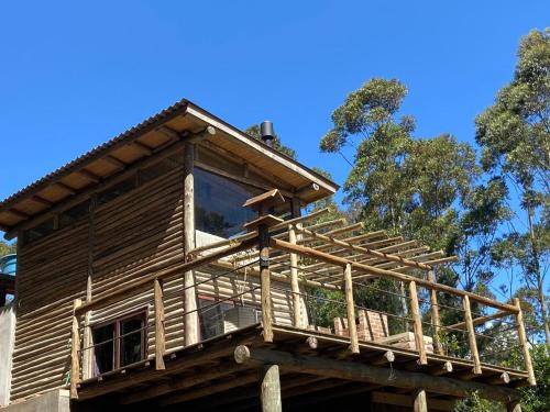 a tree house with a wrap around deck at Cabana rústica estilo logcabin. in Osório