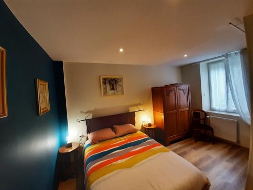 a bedroom with a bed with a colorful blanket at le Plain Pied sur place in Le Mêle-sur-Sarthe