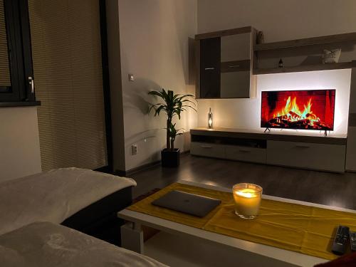a living room with a fireplace and a table with a candle at Cozy Residental Apartment in Košice