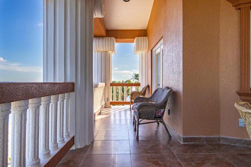 a room with a balcony with a chair and a window at Lighthouse Beach Villas in San Pedro